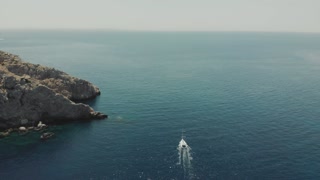 Aerial View of Yacht near Ibiza and Balearic Islands. Drone Footage of Yachting in Beautiful Rocky Islands. People on Yacht.