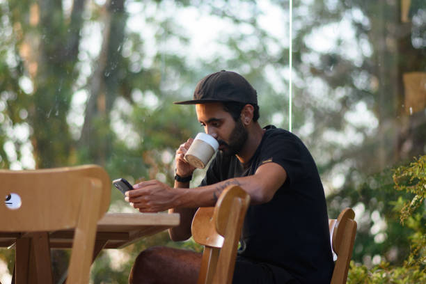 Young adult uses a cell phone in a coffee shop