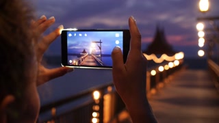 Woman Taking Night View Photos Using Mobile Phone